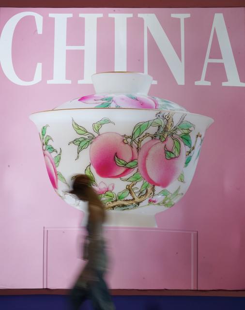 (251021) -- NANCHANG, Oct. 21, 2025 (Xinhua) -- A visitor walks past a poster displaying a ceramic work during the 2025 China Jingdezhen International Ceramic Expo in Jingdezhen, east China's Jiangxi Province, Oct. 18, 2025. (Xinhua/Zhou Mi)