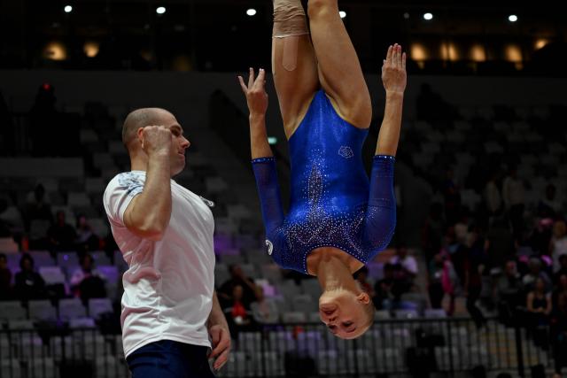 (251021) -- JAKARTA, Oct. 21, 2025 (Xinhua) -- Angelina Melnikova (R) of AIN (Individual Neutral Athlete) practices with team official before the Women's Floor Exercise Qualification at the 53rd FIG World Artistic Gymnastics Championships in Jakarta, Indonesia, on Oct. 21, 2025. (Xinhua/Agung Kuncahya B.)