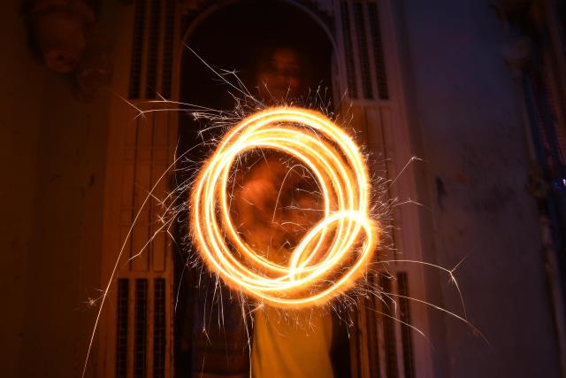 (251021) -- KARACHI(PAKISTAN), Oct. 21, 2025 (Xinhua) -- A woman plays with fireworks to celebrate Diwali, or the festival of lights, in southern Pakistani port city of Karachi, Oct. 21, 2025. (Str/Xinhua)