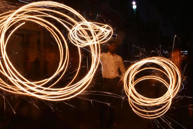 (251021) -- KARACHI(PAKISTAN), Oct. 21, 2025 (Xinhua) -- People play with fireworks to celebrate Diwali, or the festival of lights, in southern Pakistani port city of Karachi, Oct. 21, 2025. (Str/Xinhua)