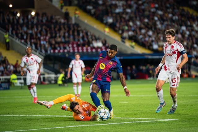 (251022) -- BARCELONA, Oct. 22, 2025 (Xinhua) -- Marcus Rashford (2nd R) of FC Barcelona vies with Konstantinos Tzolakis, goalkeeper of Olympiacos during the Champions League football match between FC Barcelona and Olympiacos in Barcelona, Spain, Oct. 21, 2025. (Photo by Joan Gosa/Xinhua)