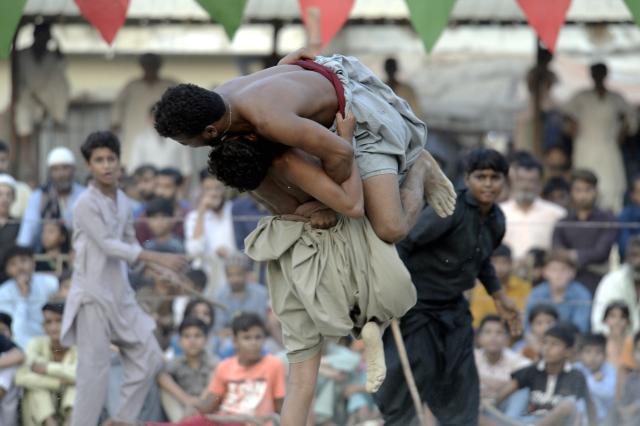 (251022) --  KARACHI, Oct. 22, 2025 (Xinhua) -- Wrestlers compete in a "Sindhi Malakhra" wrestling match in southern Pakistani port city of Karachi on Oct. 21, 2025. Sindhi Malakhra is an ancient form of wrestling that originated in Pakistan's Sindh region. (Str/Xinhua)
