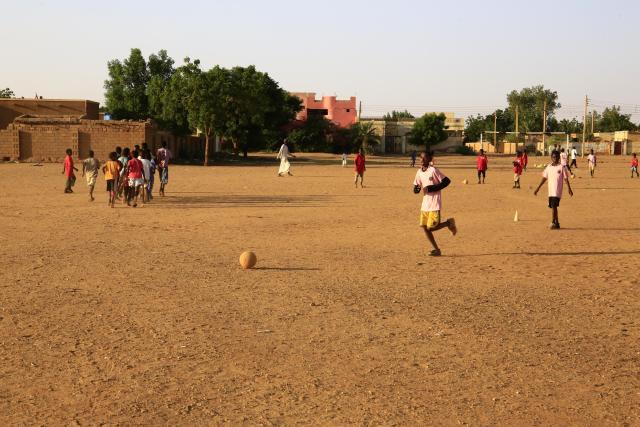 (251022) -- KHARTOUM, Oct. 22, 2025 (Xinhua) -- Children play football on a dirt field at Al-Iskan neighborhood, District 95, west of Omdurman, Sudan, on Oct. 19, 2025. TO GO WITH "Feature: In Khartoum, football on dirt fields offers therapy for war trauma" (Photo by Mohamed Khidir/Xinhua)