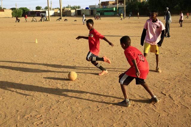 (251022) -- KHARTOUM, Oct. 22, 2025 (Xinhua) -- Children play football on a dirt field at Al-Iskan neighborhood, District 95, west of Omdurman, Sudan, on Oct. 19, 2025. TO GO WITH "Feature: In Khartoum, football on dirt fields offers therapy for war trauma" (Photo by Mohamed Khidir/Xinhua)