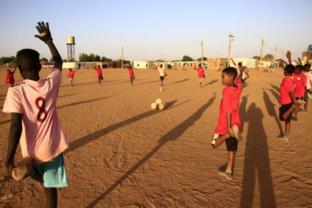 (251022) -- KHARTOUM, Oct. 22, 2025 (Xinhua) -- Children play football on a dirt field at Al-Iskan neighborhood, District 95, west of Omdurman, Sudan, on Oct. 19, 2025. TO GO WITH "Feature: In Khartoum, football on dirt fields offers therapy for war trauma" (Photo by Mohamed Khidir/Xinhua)