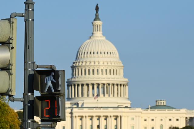 (251022) -- WASHINGTON, Oct. 22, 2025 (Xinhua) -- This photo taken on Oct. 21, 2025 shows the U.S. Capitol building behind a traffic light in Washington, D.C., the United States.
  The federal government shutdown entered its 21st day on Tuesday. (Xinhua/Li Rui)