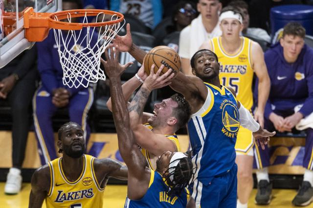 (251022) -- LOS ANGELES, Oct. 22, 2025 (Xinhua) -- Los Angeles Lakers' Luka Doncic (C) goes to the basket under the defence of Golden State Warriors' Buddy Hield (front) and Jonathan Kuminga (R) during the 2025-2026 NBA regular season match between Los Angeles Lakers and Golden State Warriors in Los Angeles, the United States, Oct. 21, 2025. (Photo by Ringo Chiu/Xinhua)