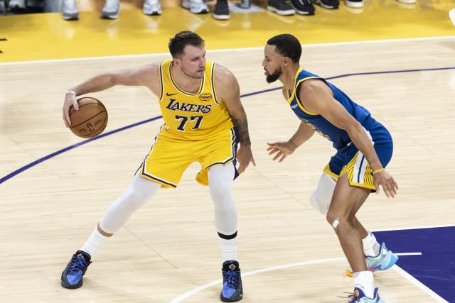 (251022) -- LOS ANGELES, Oct. 22, 2025 (Xinhua) -- Los Angeles Lakers' Luka Doncic (L) is defended by Golden State Warriors' Stephen Curry during the 2025-2026 NBA regular season match between Los Angeles Lakers and Golden State Warriors in Los Angeles, the United States, Oct. 21, 2025. (Photo by Ringo Chiu/Xinhua)
