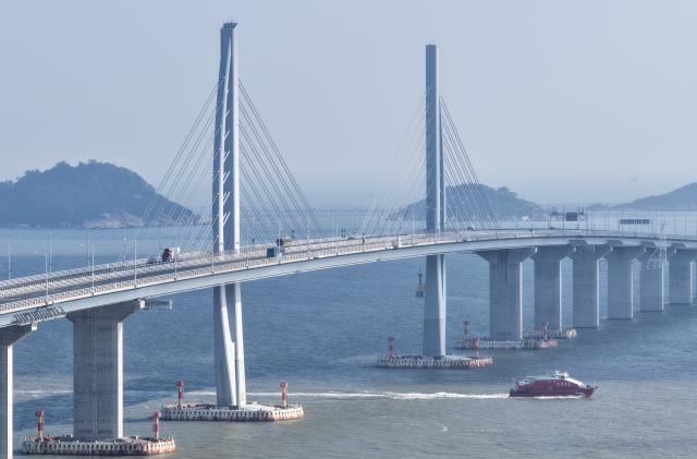 (251022) -- GUANGZHOU, Oct. 22, 2025 (Xinhua) -- An aerial drone photo taken on Oct. 19, 2025 shows cruise ships passing under the Hong Kong-Zhuhai-Macao Bridge in south China. More than 93.34 million inbound and outbound passenger trips had been recorded through the Zhuhai port of the Hong Kong-Zhuhai-Macao Bridge as of Wednesday, seven years after the bridge opened to traffic.
  According to the bridge's border inspection station, they handled 12.88 million passenger trips in 2019 and 860,000 vehicle trips that year. These numbers rose to 27 million and 5.55 million, respectively, in 2024 -- and have exceeded 25.1 million and 5.46 million, respectively, so far this year, up 17 and 25 percent year on year, respectively. (Xinhua/Deng Hua)