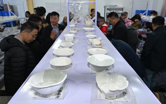 (251022) -- YINCHUAN, Oct. 22, 2025 (Xinhua) -- Archaeologists view samples of excavated porcelain at the cultural relics storage room of the archaeologist team working on the remnants of the Suyukou kiln, in Yinchuan, capital of northwest China's Ningxia Hui Autonomous Region, Oct. 13, 2025. Remnants of the Suyukou kiln were discovered in 2017 in Yinchuan, capital of Ningxia, and cover an area of roughly 40,000 square meters.
   From 2021 to 2025, archaeologists from the Ningxia Institute of Cultural Relics and Archaeology and Fudan University found remnants of workshops featuring eight furnaces, as well as pits where workers used to mine porcelain clay, coal, quartz, lime and other raw materials and fuels, which were needed to make porcelain. 
   The Suyukou site is believed to be the earliest Western Xia Dynasty kiln site found to date in China. Judging from its production scale and saggars marked with the character guan, which literally means official, archaeologists believe that the Suyukou kiln was an official kiln producing bowls, cups, plates and other daily utensils -- mainly for the royal family during the Western Xia Dynasty (1038-1227). (Xinhua/Li He)