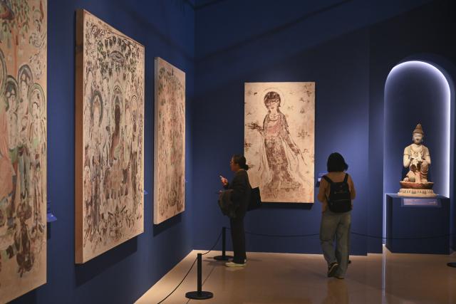 (251022) -- SHANGHAI, Oct. 22, 2025 (Xinhua) -- Guests visit the preview of the Dunhuang Culture and Art Public Benefit Exhibition in east China's Shanghai, Oct. 22, 2025. The exhibition will kick off here on Oct. 23, and will last until March 31, 2026. (Xinhua/Chen Haoming)
