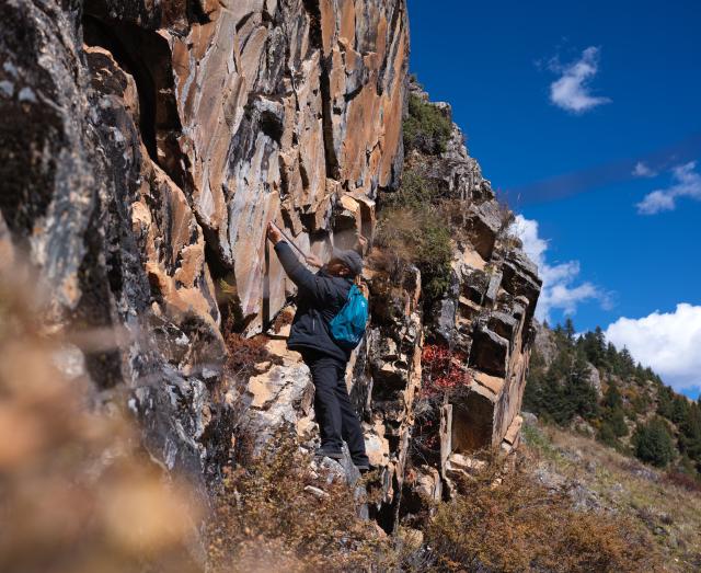 (251022) -- CHENGDU, Oct. 22, 2025 (Xinhua) -- Chen Xuesong, a cultural heritage conservator, measures a rock painting in Garze Tibetan Autonomous Prefecture, southwest China's Sichuan Province, Oct. 21, 2025. This group of rock paintings in the prefecture dates back about 8,000 years. (Xinhua/Xue Chen)