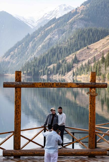 (251022) -- ALMATY, Oct. 22, 2025 (Xinhua) -- Tourists pose for photos at the Kolsai Lakes National Park in Almaty Region, Kazakhstan, on Oct. 21, 2025. (Xinhua/Li Renzi)
