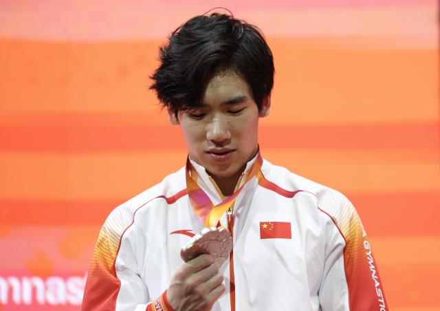 (251022) -- JAKARTA, Oct. 22, 2025 (Xinhua) -- Silver medalist Zhang Boheng of China reacts during the awarding ceremony for Men's All-Round at the 53rd FIG Artistic Gymnastics World Championships in Jakarta, Indonesia, on Oct. 22, 2025. (Xinhua/Bai Xuefei)