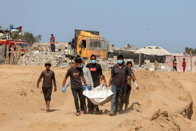 (251022) -- GAZA, Oct. 22, 2025 (Xinhua) -- This photo taken on Oct. 22, 2025 shows the burial of the unidentified bodies of Palestinians in Deir al-Balah, central Gaza Strip. (Photo by Rizek Abdeljawad/Xinhua)