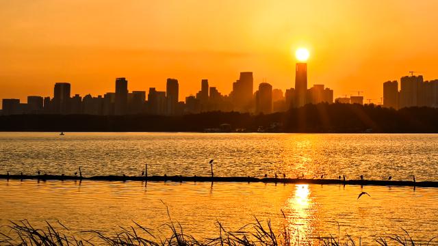 (251022) -- WUHAN, Oct. 22, 2025 (Xinhua) -- This photo taken on Oct. 22, 2025 shows Donghu Lake at sunset in Wuhan, central China's Hubei Province. (Xinhua/Shen Hongbing)