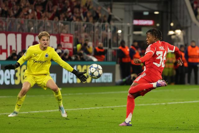 (251023) -- MUNICH, Oct. 23, 2025 (Xinhua) -- Wisdom Mike (R) of Bayern Munich shoots during the UEFA Champions League football match between Bayern Munich and Club Brugge in Munich, Germany, Oct. 22, 2025. (Photo by Philippe Ruiz/Xinhua)