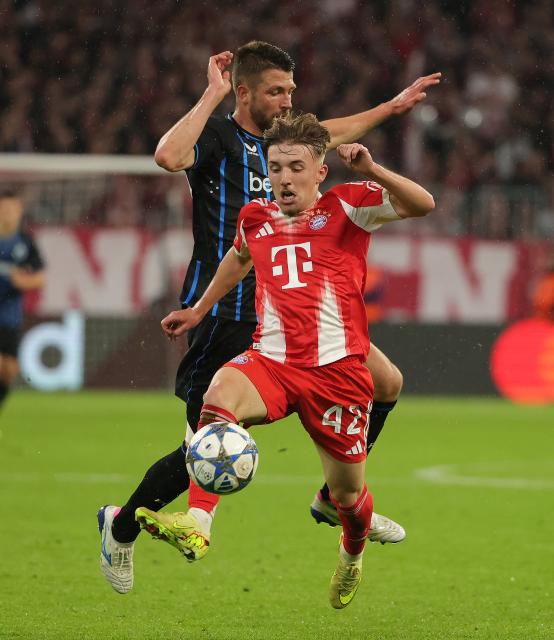 (251023) -- MUNICH, Oct. 23, 2025 (Xinhua) -- Lennart Karl (front) of Bayern Munich vies with Brandon Mechele of Club Brugge during the UEFA Champions League football match between Bayern Munich and Club Brugge in Munich, Germany, Oct. 22, 2025. (Photo by Philippe Ruiz/Xinhua)