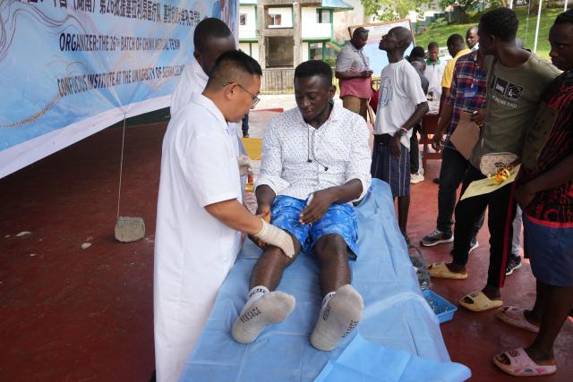 (251023) -- FREETOWN, Oct. 23, 2025 (Xinhua) -- A member of the 26th batch of the Chinese medical team to Sierra Leone performs traditional Chinese medicine diagnosis and treatment for a local resident during a cultural exchange and free clinic services event in Freetown, Sierra Leone, Oct. 22, 2025. The 26th batch of the Chinese medical team to Sierra Leone collaborated with the Confucius Institute at the University of Sierra Leone to host a cultural exchange event on Wednesday to promote traditional medicine.
   TO GO WITH "(Special for CAFS) Chinese medical team spreads traditional medicine knowledge in Sierra Leone" (The 26th batch of the Chinese medical team to Sierra Leone/Handout via Xinhua)