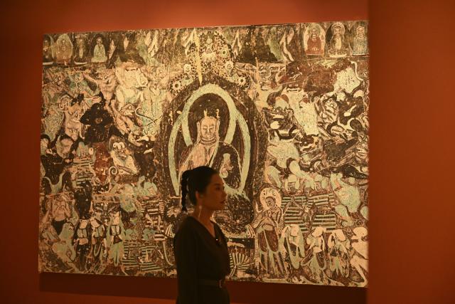 (251023) -- BEIJING, Oct. 23, 2025 (Xinhua) -- A guest visits the preview of the Dunhuang Culture and Art Public Benefit Exhibition in east China's Shanghai, Oct. 22, 2025. (Xinhua/Chen Haoming)