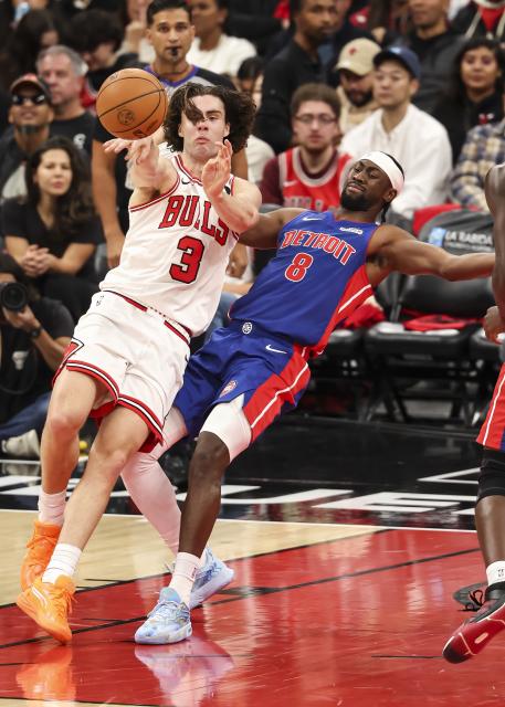 (251023) -- CHICAGO, Oct. 23, 2025 (Xinhua) -- Chicago Bulls guard Josh Giddey (L) passes the ball against Detroit Pistons' Caris Levert during the NBA regular season basketball game between Detroit Pistons and Chicago Bulls at the United Center in Chicago, the United States, on Oct. 22, 2025. (Photo by Joel Lerner/Xinhua)