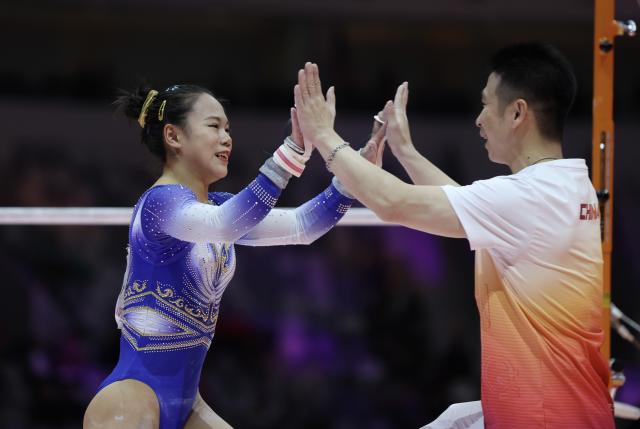 (251023) -- JAKARTA, Oct. 23, 2025 (Xinhua) -- Zhang Qingying (L) of China celebrates with her coach after the Uneven Bars of the Women's All-Round Final at the 53rd FIG Artistic Gymnastics World Championships in Jakarta, Indonesia, on Oct. 23, 2025. (Xinhua/Bai Xuefei)