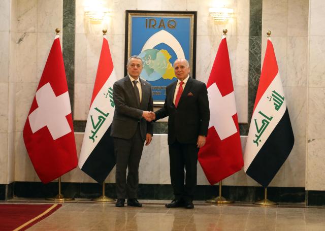 (251023) -- BAGHDAD, Oct. 23, 2025 (Xinhua) -- Iraqi Foreign Minister Fuad Hussein (R) and Swiss Federal Councilor and Foreign Minister Ignazio Cassis (L) shake hands in Baghdad, Iraq, Oct.23, 2025. Iraqi Prime Minister Mohammed Shia' al-Sudani met with a high-level Swiss delegation on Thursday to discuss enhancing bilateral cooperation and attracting Swiss investment in major Iraqi development projects, notably the Development Road initiative. (Xinhua/Khalil Dawood)