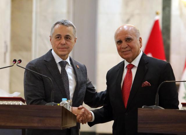 (251023) -- BAGHDAD, Oct. 23, 2025 (Xinhua) -- Iraqi Foreign Minister Fuad Hussein (R) and Swiss Federal Councilor and Foreign Minister Ignazio Cassis (L) shake hands during a joint press conference in Baghdad, Iraq, Oct.23, 2025. Iraqi Prime Minister Mohammed Shia' al-Sudani met with a high-level Swiss delegation on Thursday to discuss enhancing bilateral cooperation and attracting Swiss investment in major Iraqi development projects, notably the Development Road initiative. (Xinhua/Khalil Dawood)