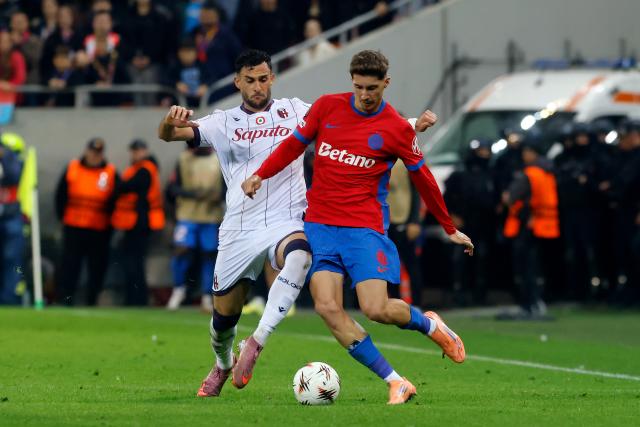 (251024) -- BUCHAREST, Oct. 24, 2025 (Xinhua) -- FCSB's David Miculescu (R) vies with Bologna's Charalampos Lykogiannis during their UEFA Europa League football match in Bucharest, Romania, Oct. 23, 2025. (Photo by Cristian Cristel/Xinhua)