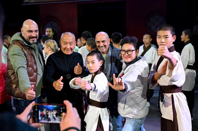 (251024) -- ZHENGZHOU, Oct. 24, 2025 (Xinhua) -- Guests pose for a group photo after watching a show at Shaolin Temple scenic area in Dengfeng City, central China's Henan Province, Oct. 23, 2025. The Global Mayors Dialogue and the International Mayor's Forum on Tourism in Zhengzhou kicked off here on Friday. Guests attending the events had visited Henan Museum, Shaolin Temple and other places on Wednesday and Thursday to experience the charm of Henan. (Xinhua/Hao Yuan)