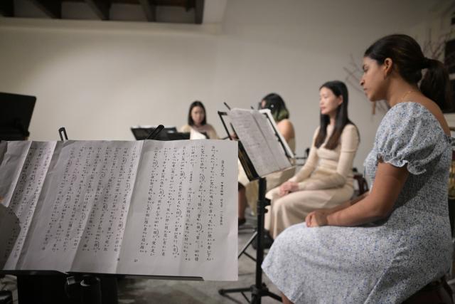 (251024) -- SINGAPORE, Oct. 24, 2025 (Xinhua) -- Nadya Tasha Lim (R), a member of a music society named Siong Leng, learns Nanyin in Singapore on Jan. 13, 2025. Nanyin, which originated from southeast China's Fujian Province, is known as the "living fossil" of ancient Chinese music and literally means music in the south. It is a traditional opera in Fujian dialect.
In 2009, Nanyin was listed as a World Human Verbal and Intangible Cultural Heritage by UNESCO.
   The inheritance of Nanyin relies on dedicated practitioners. Cai Liyong, a Nanyin artist who started learning Nanyin since childhood, teaches Nanyin to students at a primary school in Jinjiang of Fujian Province every week, promoting authentic Nanyin among young students.
   In Singapore, a music society named Siong Leng is also dedicated to the preserving and promoting Nanyin. Established in 1941, Siong Leng made several successful performances in cities including Paris, Tokyo, and New York.
   From China to Singapore, from classrooms to the global stage, Nanyin weaves a continuous thread through cultural memories at home and abroad. (Photo by Then Chih Wey/Xinhua)