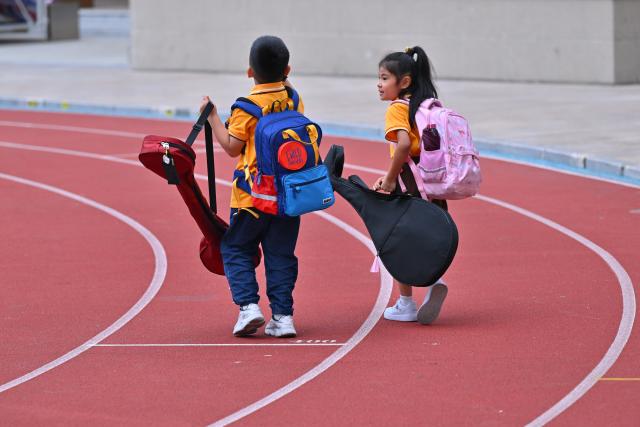 (251024) -- QUANZHOU, Oct. 24, 2025 (Xinhua) -- Students walk on the playground after a Nanyin class at a primary school in Jinjiang, southeast China's Fujian Province, on Oct. 23, 2025. Nanyin, which originated from southeast China's Fujian Province, is known as the "living fossil" of ancient Chinese music and literally means music in the south. It is a traditional opera in Fujian dialect.
In 2009, Nanyin was listed as a World Human Verbal and Intangible Cultural Heritage by UNESCO.
   The inheritance of Nanyin relies on dedicated practitioners. Cai Liyong, a Nanyin artist who started learning Nanyin since childhood, teaches Nanyin to students at a primary school in Jinjiang of Fujian Province every week, promoting authentic Nanyin among young students.
   In Singapore, a music society named Siong Leng is also dedicated to the preserving and promoting Nanyin. Established in 1941, Siong Leng made several successful performances in cities including Paris, Tokyo, and New York.
   From China to Singapore, from classrooms to the global stage, Nanyin weaves a continuous thread through cultural memories at home and abroad. (Xinhua/Jiang Kehong)