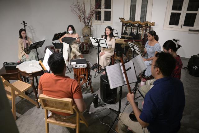 (251024) -- SINGAPORE, Oct. 24, 2025 (Xinhua) -- Members of a music society named Siong Leng learn Nanyin in Singapore on Jan. 13, 2025. Nanyin, which originated from southeast China's Fujian Province, is known as the "living fossil" of ancient Chinese music and literally means music in the south. It is a traditional opera in Fujian dialect.
In 2009, Nanyin was listed as a World Human Verbal and Intangible Cultural Heritage by UNESCO.
   The inheritance of Nanyin relies on dedicated practitioners. Cai Liyong, a Nanyin artist who started learning Nanyin since childhood, teaches Nanyin to students at a primary school in Jinjiang of Fujian Province every week, promoting authentic Nanyin among young students.
   In Singapore, a music society named Siong Leng is also dedicated to the preserving and promoting Nanyin. Established in 1941, Siong Leng made several successful performances in cities including Paris, Tokyo, and New York.
   From China to Singapore, from classrooms to the global stage, Nanyin weaves a continuous thread through cultural memories at home and abroad. (Photo by Then Chih Wey/Xinhua)
