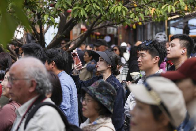 (251024) -- DEQING, Oct. 24, 2025 (Xinhua) -- Tourists watch the performances during a dance festival in the ancient town of Xinshi of Deqing County, east China's Zhejiang Province, on Oct. 24, 2025. (Xinhua/Huang Zongzhi)