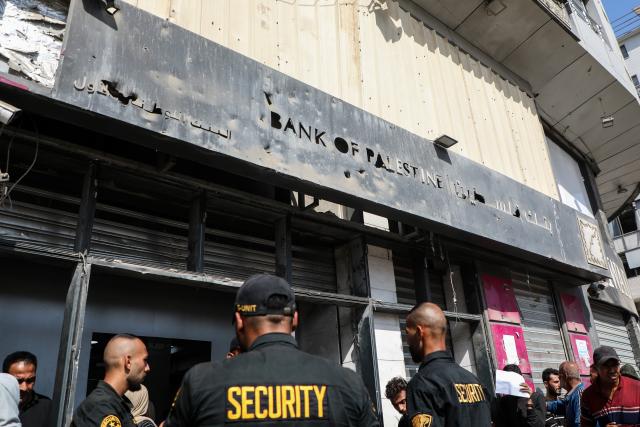 (251024) -- GAZA, Oct. 24, 2025 (Xinhua) -- Palestinians wait outside a branch of Bank of Palestine in Gaza City, on Oct. 23, 2025. Banks have reopened administratively but remain unable to bring cash into the Strip after two years of war. (Photo by Rizek Abdeljawad/Xinhua)