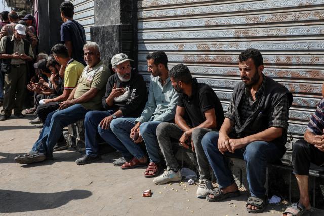(251024) -- GAZA, Oct. 24, 2025 (Xinhua) -- Palestinians wait outside a branch of Bank of Palestine in Gaza City, on Oct. 23, 2025. Banks have reopened administratively but remain unable to bring cash into the Strip after two years of war. (Photo by Rizek Abdeljawad/Xinhua)