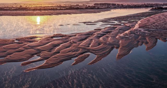 (251025) -- BEIJING, Oct. 25, 2025 (Xinhua) -- An aerial drone photo taken on Oct. 24, 2025 shows the Wusuli River in the morning light in Raohe County, northeast China's Heilongjiang Province. (Photo by Sheng Jingli/Xinhua)