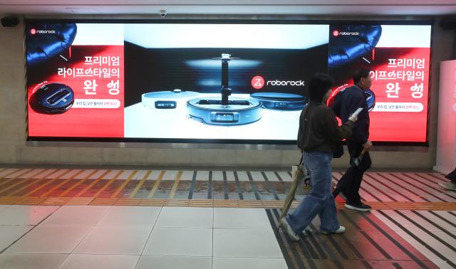 (251025) -- SEOUL, Oct. 25, 2025 (Xinhua) -- People walk by a billboard of Roborock at a subway station in Seoul, South Korea, Oct. 13, 2025. At a large shopping mall in Seoul, South Korea, a Chinese brand's robot vacuum cleaner attracted bustling crowds. A Roborock robot vacuum cleaner, equipped with a robotic arm, precisely picked up a sock, rotated, and threw it into a box, drawing cheers from the audience.
   According to data from a U.S. research firm, Roborock holds over 50 percent market share in South Korea's robot vacuum cleaner market, firmly securing the top position, with a dominance market share exceeding 70 percent in the high-end market. 
   Beyond South Korea, Roborock is rapidly expanding across other Asia-Pacific markets. In Japan, during a promotion on Amazon Japan, several Roborock products ranked among the most popular robot vacuum cleaners. In Australia, its products also made it into the top ten best-selling robot vacuum cleaner list.
   Over 2,000 kilometers away from South Korea, in Huizhou City of south China's Guangdong Province, Roborock's smart manufacturing facility operates at high efficiency, with robot vacuum cleaners continuously distributed worldwide.
   From workshops in China to living rooms across Asia-Pacific, Chinese brands for robot vacuum cleaners have gained popularity among foreign customers. (Xinhua/Yao Qilin)
