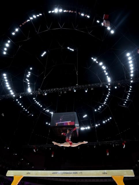 (251025) -- JAKARTA, Oct. 25, 2025 (Xinhua) -- Zhang Qingying of China competes during the women's balance beam final at 53rd FIG Artistic Gymnastics World Championships in Jakarta, Indonesia, on Oct. 25, 2025. (Xinhua/Bai Xuefei)
