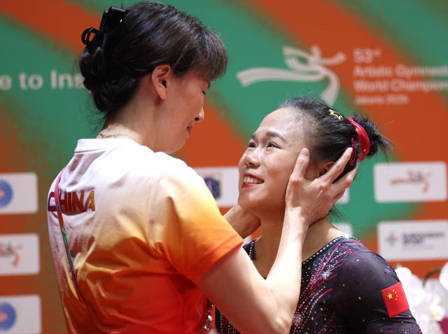 (251025) -- JAKARTA, Oct. 25, 2025 (Xinhua) -- Zhang Qingying (R) of China and her coach Xu Jinglei celebrate winning the women's balance beam final at 53rd FIG Artistic Gymnastics World Championships in Jakarta, Indonesia, on Oct. 25, 2025. (Xinhua/Bai Xuefei)