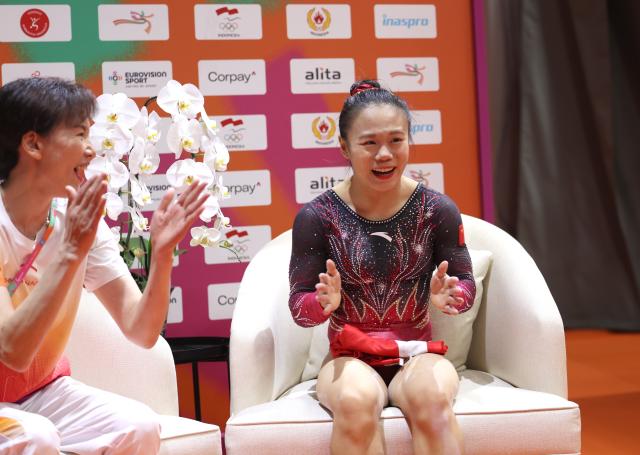 (251025) -- JAKARTA, Oct. 25, 2025 (Xinhua) -- Zhang Qingying (R) of China and her coach Xu Jinglei celebrate winning the women's balance beam final at 53rd FIG Artistic Gymnastics World Championships in Jakarta, Indonesia, on Oct. 25, 2025. (Xinhua/Bai Xuefei)