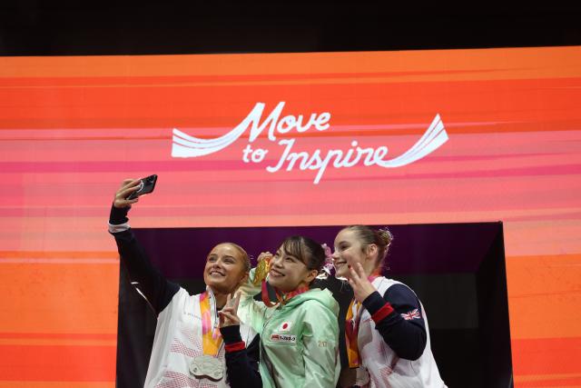 (251025) -- JAKARTA, Oct. 25, 2025 (Xinhua) -- Gold medalist Sugihara Aiko (C) of Japan, silver medalist Ruby Evans (L) of Britain and bronze medalist Abigail Martin of Britain take selfies during the awarding ceremony after the women's Floor Exercise Final at 53rd FIG Artistic Gymnastics World Championships in Jakarta, Indonesia, on Oct. 25, 2025. (Xinhua/Bai Xuefei)