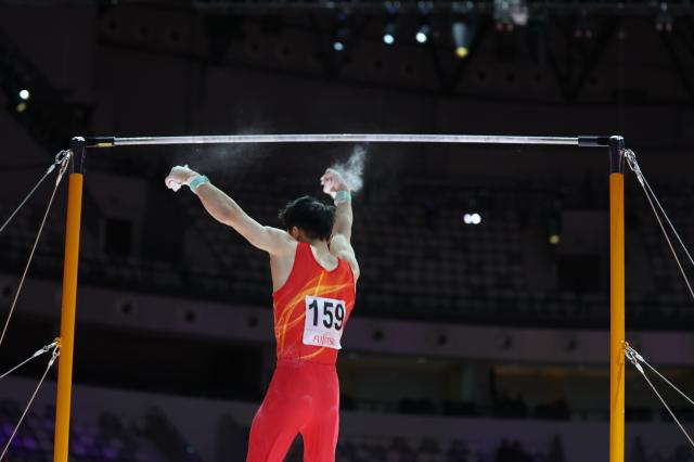 (251025) -- JAKARTA, Oct. 25, 2025 (Xinhua) -- Shi Cong of China falls off the bar during the men's Horizontal Bar Final at 53rd FIG Artistic Gymnastics World Championships in Jakarta, Indonesia, on Oct. 25, 2025. (Xinhua/Bai Xuefei)
