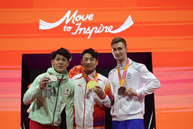 (251025) -- JAKARTA, Oct. 25, 2025 (Xinhua) -- Gold medalist Zou Jingyuan (C) of China, silver medalist Tsunogai Tomoharu (L) of Japan and bronze medalist Daniel Marinov of AIN (Individual Neutral Athlete) pose during the awarding ceremony for the Men's Parallel Bars at 53rd FIG Artistic Gymnastics World Championships in Jakarta, Indonesia, on Oct. 25, 2025. (Xinhua/Bai Xuefei)