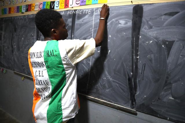 (251026) -- ABIDJAN, Oct. 26, 2025 (Xinhua) -- A staff member writes the names of candidates on a blackboard at a polling station in Abidjan, Cote d'Ivoire, Oct. 25, 2025. Polling stations for Cote d'Ivoire's presidential election closed at 6 p.m. local time on Saturday, marking the beginning of vote counting in Abidjan, local media reported. (Photo by Yvan Sonh/Xinhua)