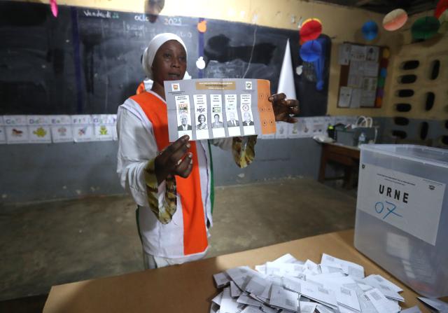 (251026) -- ABIDJAN, Oct. 26, 2025 (Xinhua) -- A staff member shows a ballot at a polling station in Abidjan, Cote d'Ivoire, Oct. 25, 2025. Polling stations for Cote d'Ivoire's presidential election closed at 6 p.m. local time on Saturday, marking the beginning of vote counting in Abidjan, local media reported. (Photo by Yvan Sonh/Xinhua)