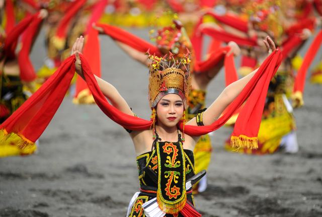 (251026) -- BANYUWANGI, Oct. 26, 2025 (Xinhua) -- A dancer performs in a mass traditional Gandrung dance during the Gandrung Sewu Festival 2025 at Marina Boom Beach in Banyuwangi, East Java, Indonesia, on Oct. 25, 2025. (Photo by Sahlan Kurniawan/Xinhua)