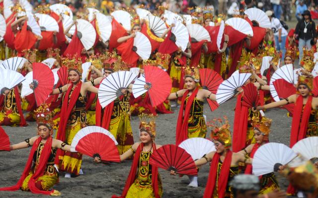 (251026) -- BANYUWANGI, Oct. 26, 2025 (Xinhua) -- Dancers perform in a mass traditional Gandrung dance during the Gandrung Sewu Festival 2025 at Marina Boom Beach in Banyuwangi, East Java, Indonesia, on Oct. 25, 2025. (Photo by Sahlan Kurniawan/Xinhua)
