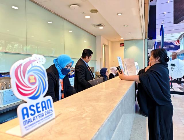 (251026) -- KUALA LUMPUR, Oct. 26, 2025 (Xinhua) -- A journalist consults staff members at the press center of the 47th Association of Southeast Asian Nations (ASEAN) Summit in Kuala Lumpur, Malaysia, Oct. 26, 2025.
  The 47th ASEAN Summit and related summits kicked off in Kuala Lumpur, Malaysia, on Sunday under the theme "Inclusivity and Sustainability." (Xinhua/Xing Guangli)