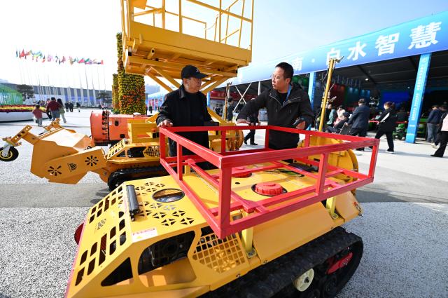 (251026) -- YANGLING, Oct. 26, 2025 (Xinhua) -- An exhibitor introduces an air-assisted sprayer with self-propelled tracks to a visitor during the 32nd China Yangling Agricultural Hi-Tech Fair in Yangling, northwest China's Shaanxi Province, Oct. 26, 2025. The agricultural hi-tech fair kicked off here on Saturday, highlighting a competition for agricultural robots as well as an exhibition on smart agricultural machinery. (Xinhua/Li Yibo)